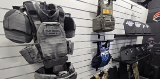 From the Streets to the Lab: How Real-World Threats Are Shaping the Future of Body Armor A tactical mannequin wearing modern camouflage body armor and helmet is displayed at a defense exhibition booth, illustrating the latest advancements in body armor innovation and protective gear for military and law enforcement.